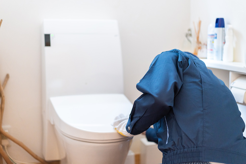 Photo d'un plombier installant un WC - placement WC salle de bain