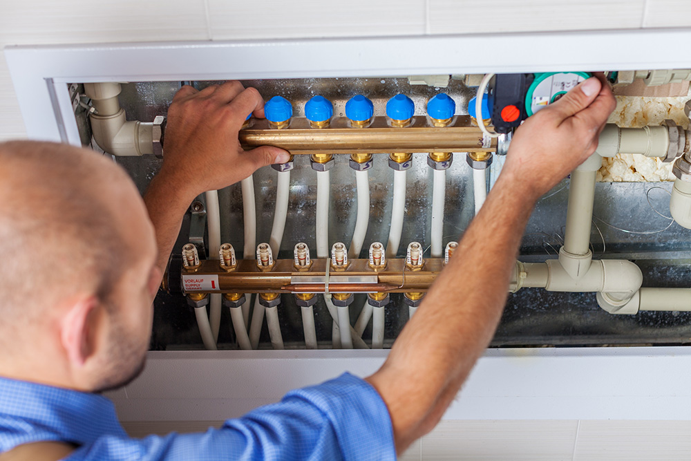 Photo d'un plombier faisant l'installation d'un réseau de chauffage